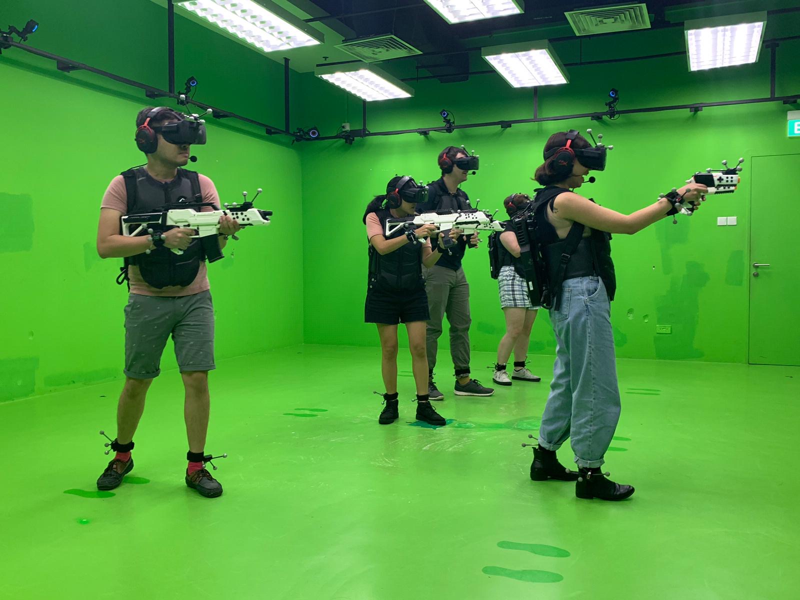 Photo of me playing a virtual reality shooting game with friends